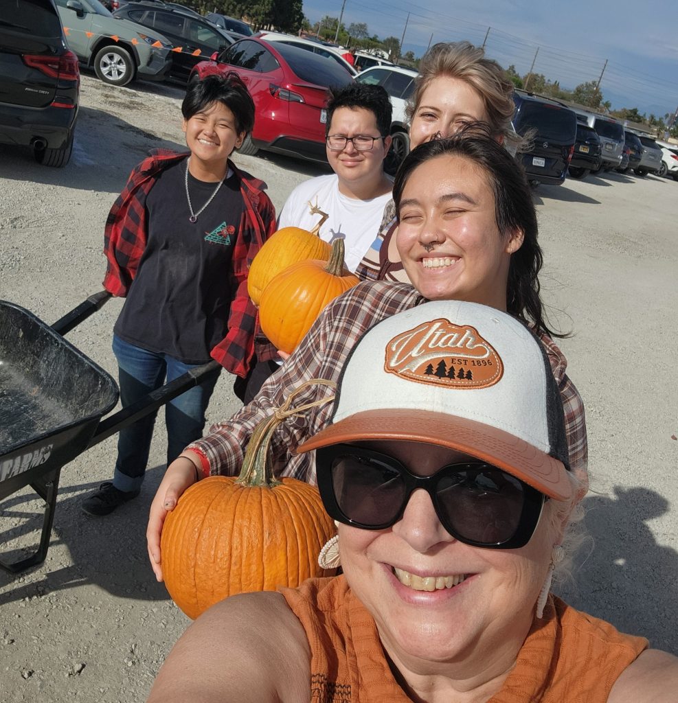 Selfie of Pastor Monica and the young adults holding their pumpkins in a line.