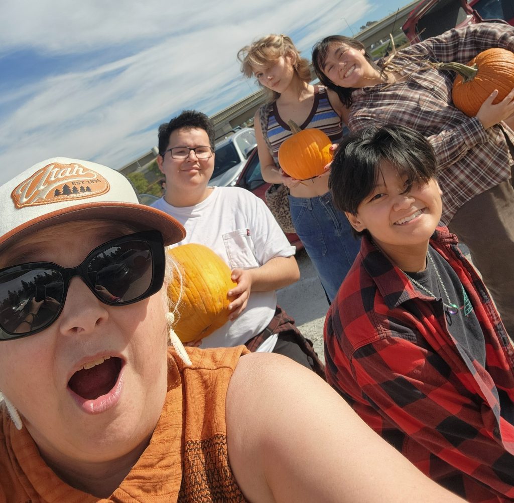 Selfie of Pastor Monica and the young adults holding their pumpkins in a group.