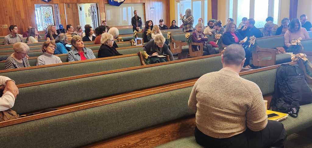 People sitting in church pews focused on the workshop