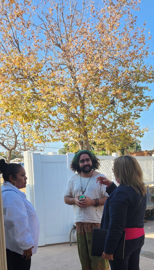 Three workshop attendees discussing while standing on the patio