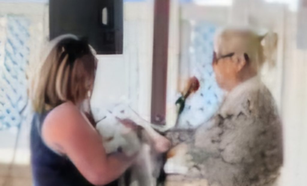 Pastor Monica blessing a white fluffy dog.